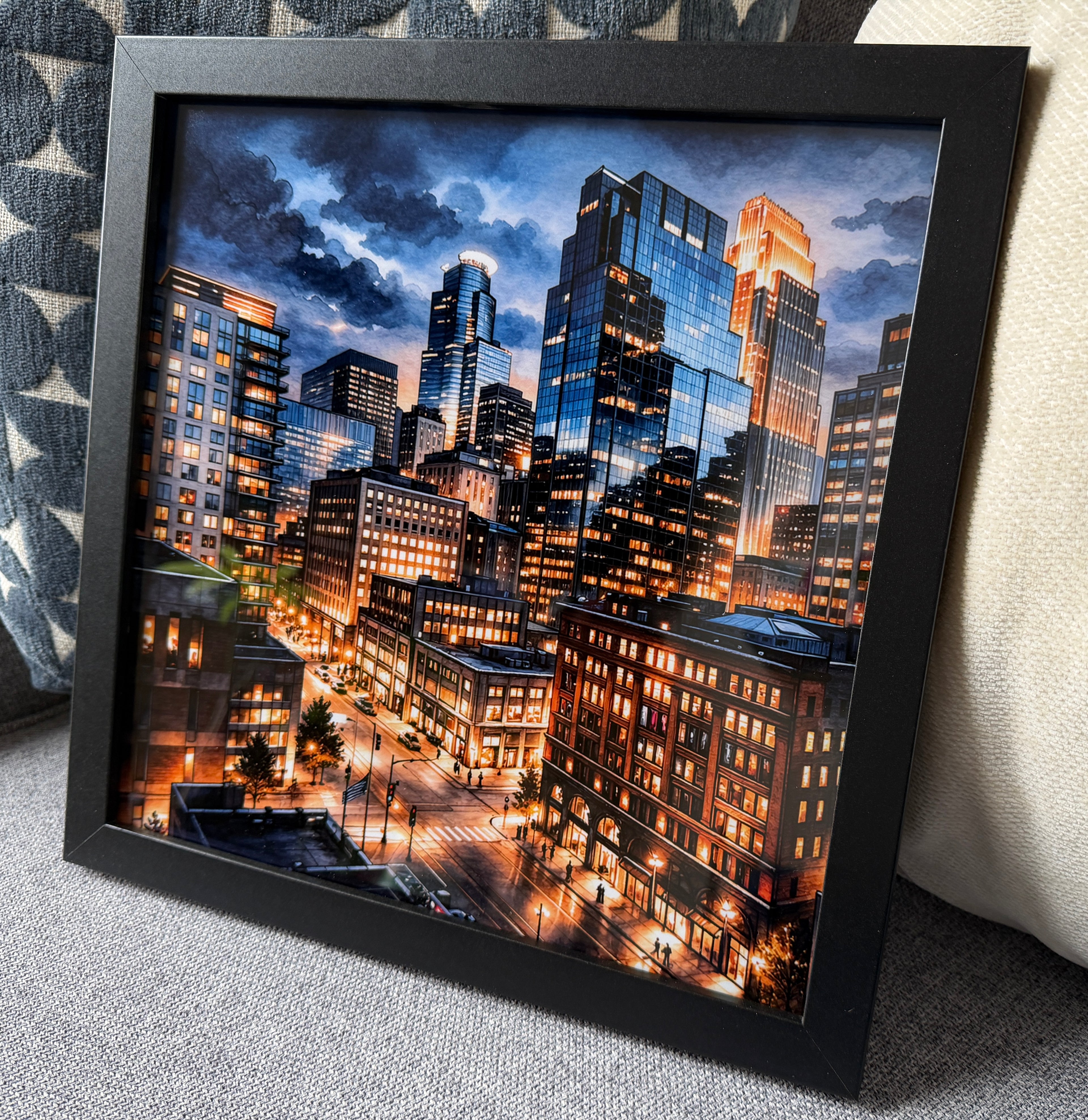 Framed cityscape artwork with illuminated buildings at night