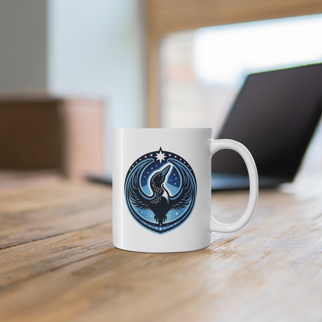 White mug with a blue and black design on a wooden surface