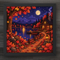 A framed square art print depicting a cozy autumn lakeside cabin scene at night, with glowing windows, a full moon, mountains in the distance, pumpkins, lanterns, and red-orange foliage. The artwork is shown in a dark frame against a dark wood background.