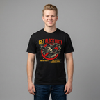 A smiling young man wearing a black graphic t-shirt with a red and yellow 'Get Flock Out!' design, paired with blue jeans, standing against a solid gray studio background.