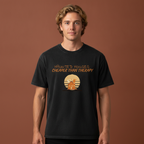 A man wearing a black graphic t-shirt that reads 'Haunted Houses: Cheaper Than Therapy' with a haunted house emblem below on a terracotta studio background.