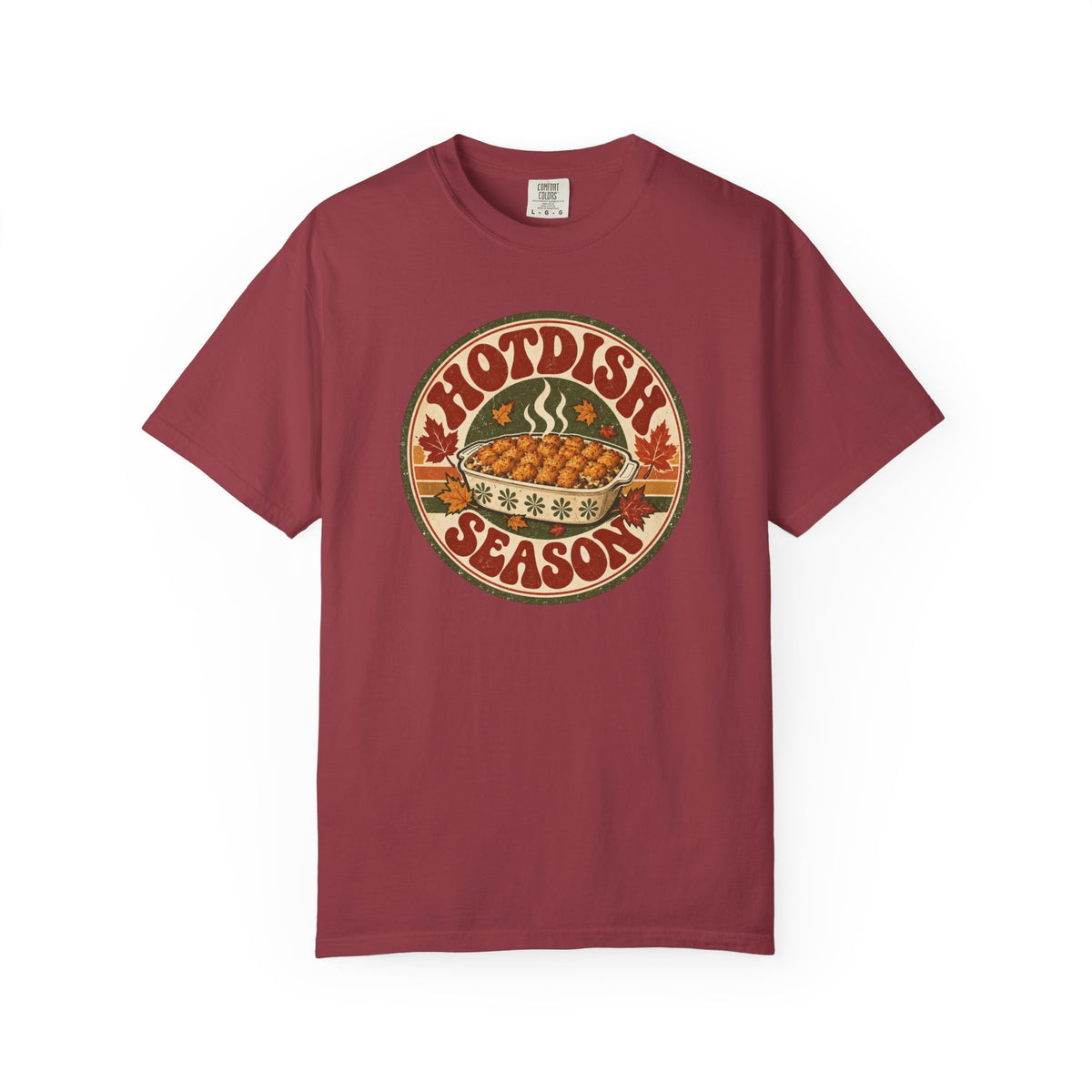 A red t-shirt with a circular retro-style graphic that reads 'HOTDISH SEASON' around an illustration of a hot casserole dish, photographed on a clean white background.