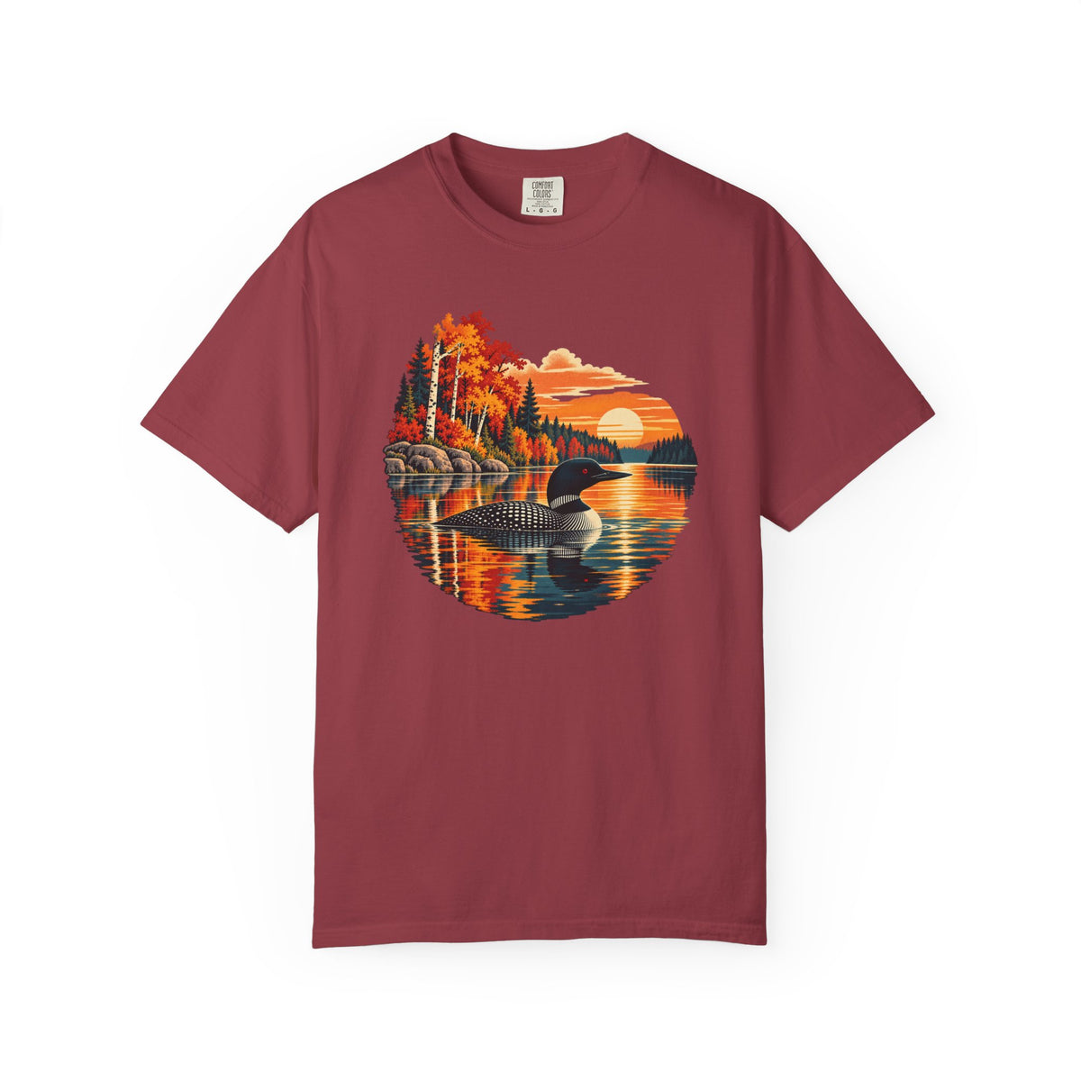 A maroon short-sleeve crewneck t-shirt featuring a circular graphic print of a loon in a lake surrounded by autumn trees and a sunset.