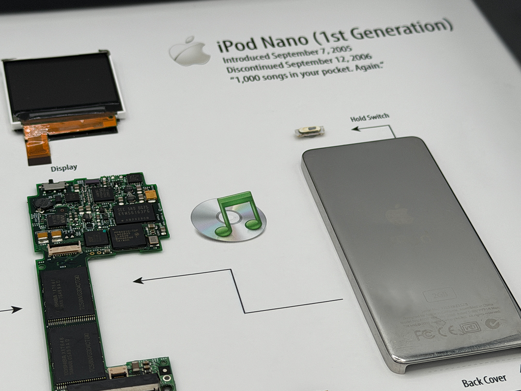 Disassembled iPod Nano 1st generation with Apple logo and text on a white background