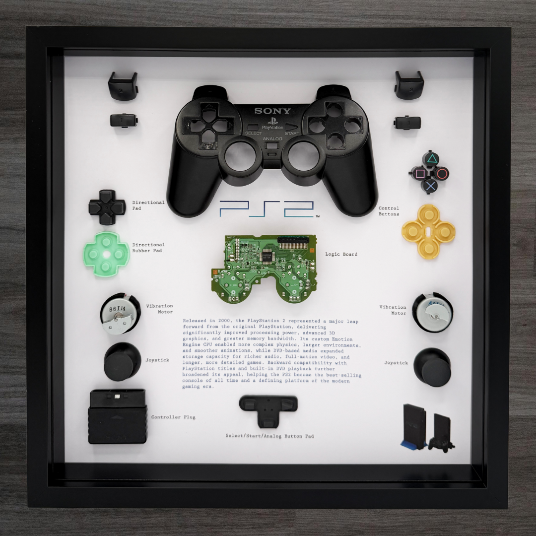 Sony PlayStation 2 controller parts displayed in a framed shadow box with text and diagrams.