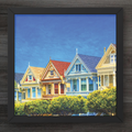 Framed artwork of colorful houses against a blue sky