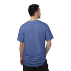 Man wearing a blue t-shirt, standing against a white background.