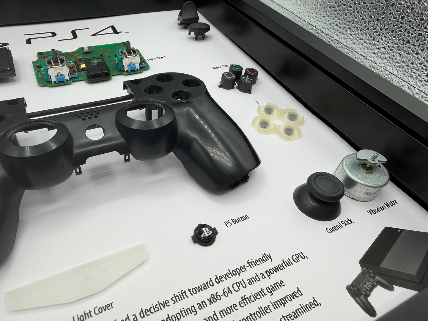 Disassembled PS4 gaming controller on a white surface with text and branding.