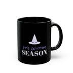 A black ceramic mug with a glossy finish, featuring a graphic design of a purple witch hat and the text 'It's Witchy SEASON' in purple and white, set against a plain white background.