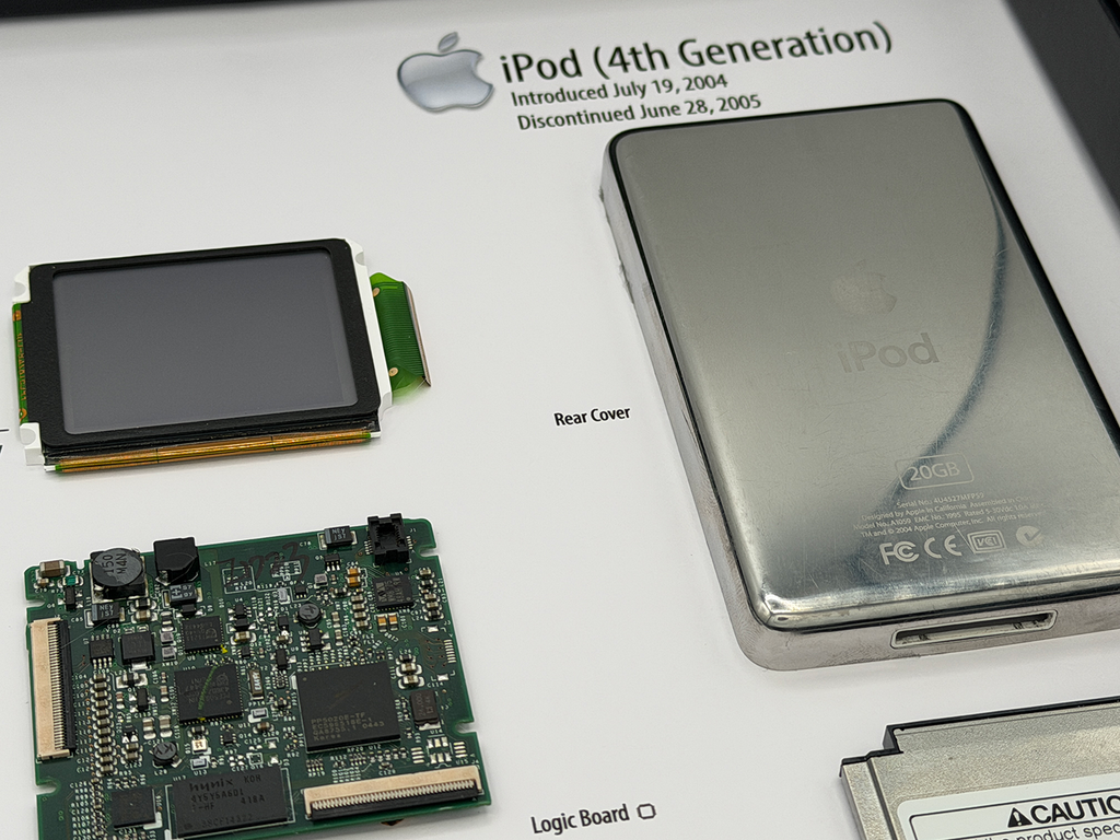 Disassembled iPod with components on a display board showing 'iPod (4th Generation)'