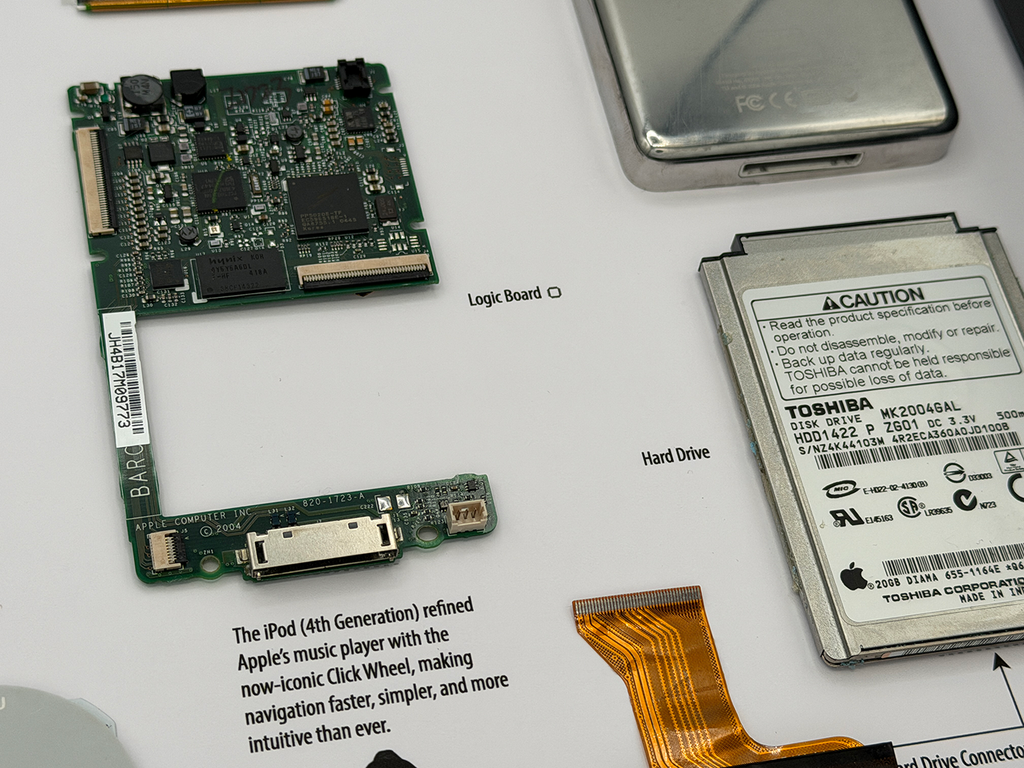 iPod Classic 4th gen components including a logic board and hard drive on a white surface with text.